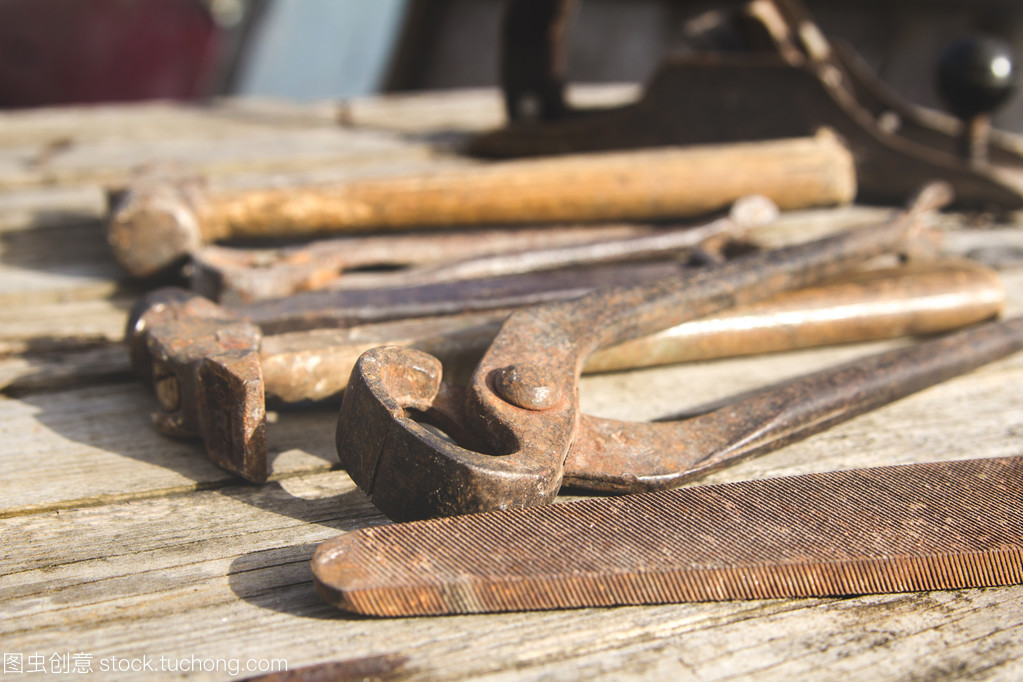 生锈套手工具在一个木制的背景上。老式照片